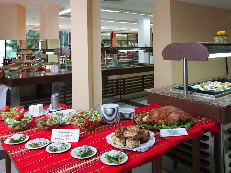 Bufet s různými jídly včetně chleba, salátů a uzenin na červené látce