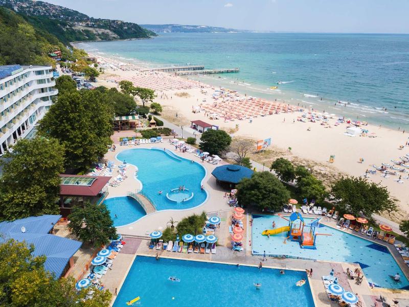 Hotelový komplex s několika bazény a nedalekou písečnou pláží s lehátky u moře.