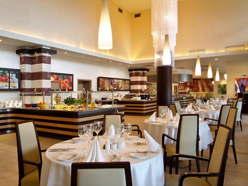 Elegantní restaurace s kulatými prostřenými stoly a moderními dřevěnými detaily.