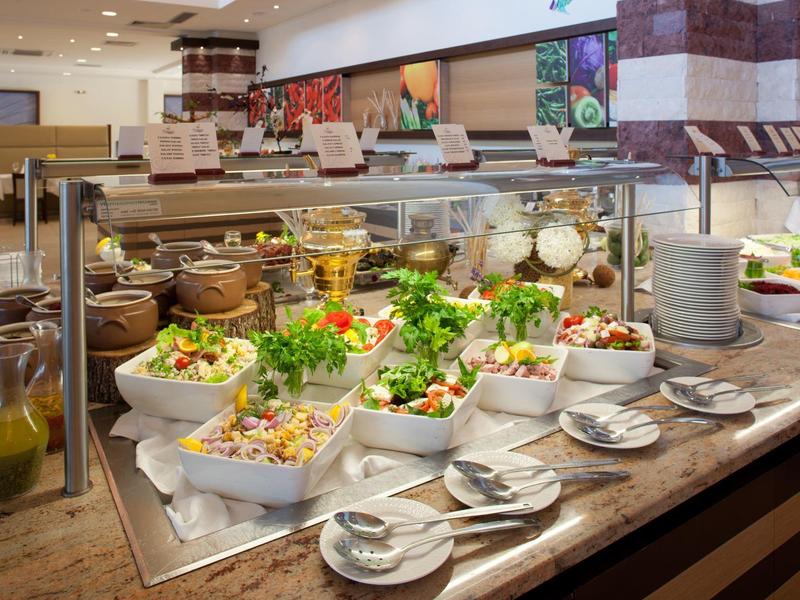 Bufet s různými saláty a dresinky v restauraci nebo hotelu