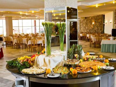 Zone d'accueil lumineuse avec comptoir moderne en bois et marbre et une personne.