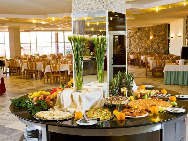 Nowoczesna recepcja hotelowa z jasnym drewnem, ławką i dwoma ekranami na ścianie