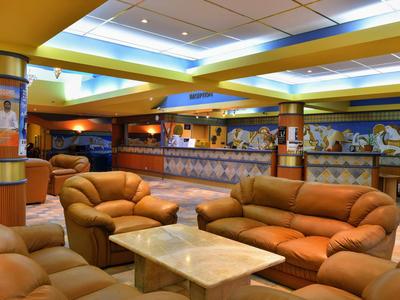 Gemütliche Sitzgruppe mit braunen Sofas und Tischen in einem Hotel-Loungebereich.