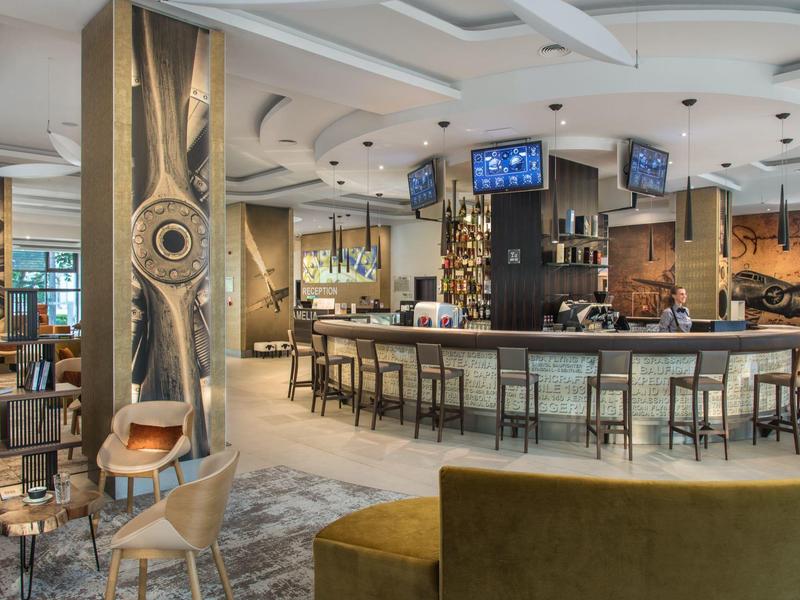 Moderní hotelový bar s elegantním barem a stylovým interiérem.