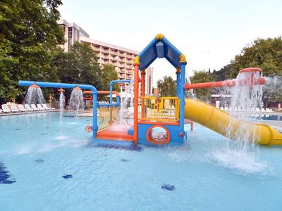 Barevné vodní hřiště s tobogány a vodními prvky v hotelovém venkovním bazénu.