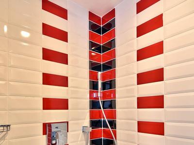 Dusche mit weißen Fliesen und roten Streifen, moderne Regendusche in der Raumecke installiert.