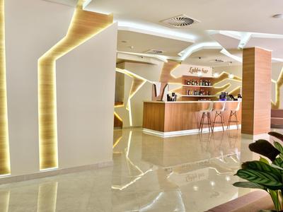 Nowoczesna recepcja hotelowa z oświetlonymi elementami ściennymi i przyjaznym stanowiskiem.