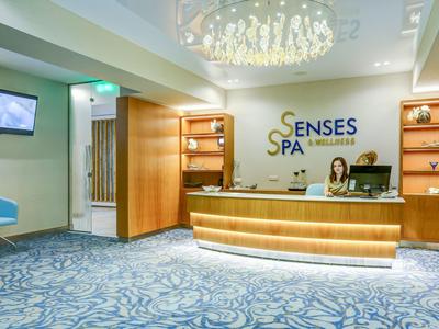 Moderní spa recepce s pultem a modrými sedadly.