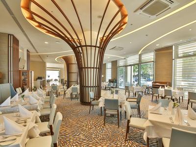 Elegantní hotelová restaurace s stylovými stoly a moderním osvětlením.