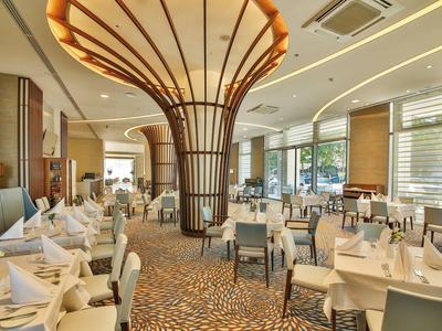 Elegant restaurant met stijlvolle verlichting en gedekte tafels in een hotel.