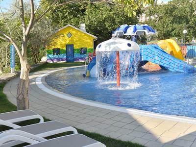 Parque acuático colorido para niños con toboganes en área exterior soleada.