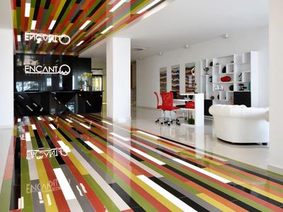 Moderne hotel lobby met kleurrijke gestreepte vloer en bijpassende plafondelementen.