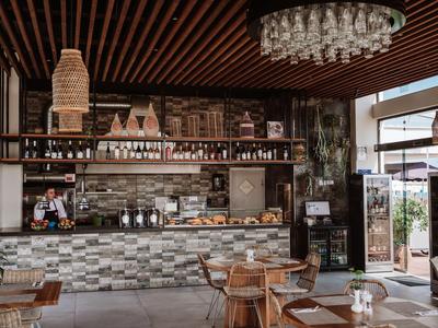 Modern eingerichtete Hotelbar mit Holz- und Steinakzenten, Glaslampen und Sitzbereichen.
