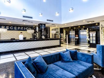 Moderne Hotelrezeption mit blauem Sofa und elegantem Empfangstresen.