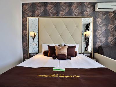 Cama doble en habitación de hotel con cabecero acolchado y cojines decorativos.