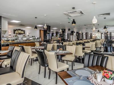 Großer, moderner Speisesaal mit zahlreichen Tischen und Stühlen in einem Hotel.