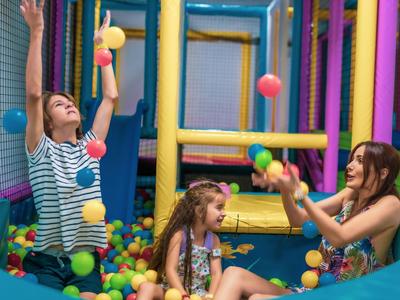 Kinderen spelen vrolijk in een kleurrijk ballenbad met plastic ballen.