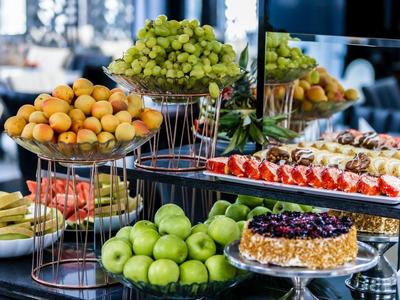 Gevarieerd buffet met vers fruit en taart in een elegant hotelrestaurant.