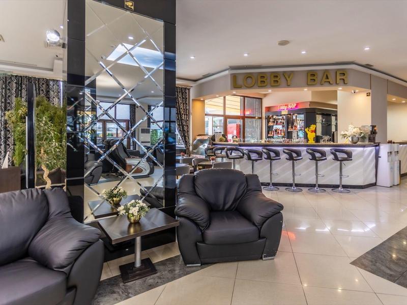 Moderne hotelbar met zwarte leren banken en stijlvolle krukken bij de bar.