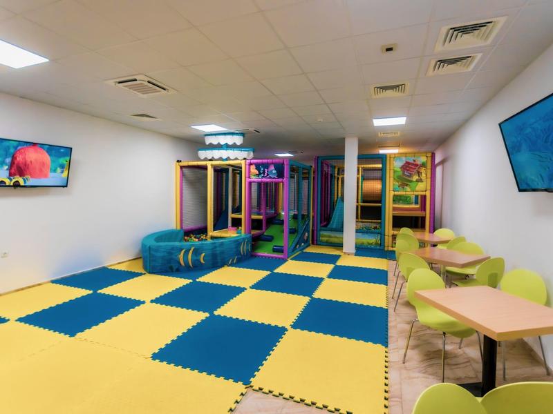 Een kleurrijk binnen speelruimte met zitplaatsen in een hotel.