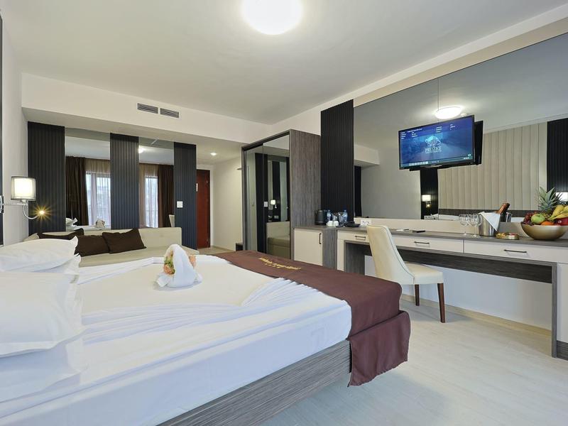 Moderne hotelkamer met tweepersoonsbed, flatscreen-tv en werkruimte.