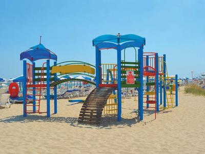 Kleurrijke kinderspeelplaats op zandstrand onder heldere hemel