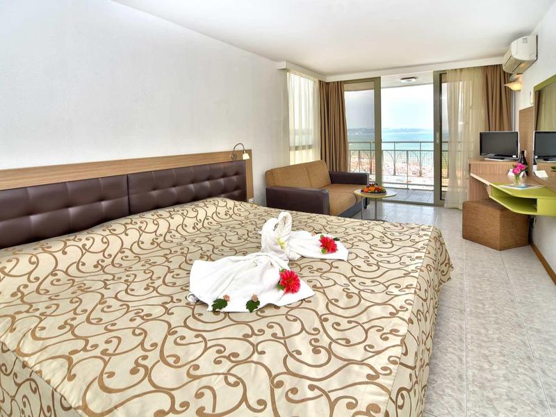 Modern hotelkamer met groot bed, balkon en uitzicht op zee