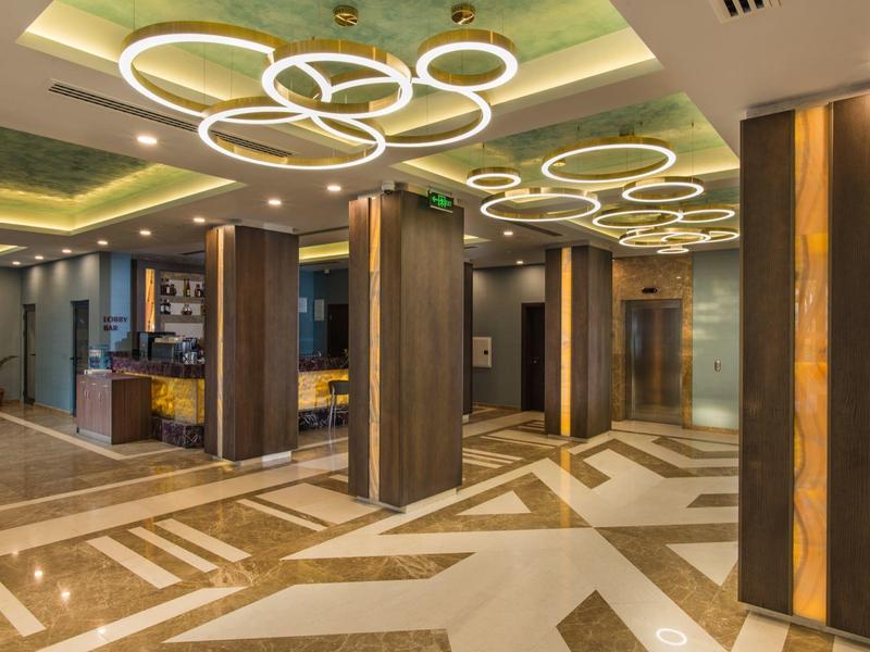 Moderner Hotelflurbereich mit stilvollen Deckenleuchten und geometrischen Bodenmustern.