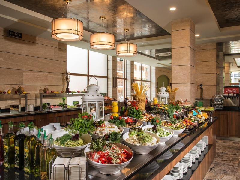 Buffet mit vielfältigen frischen Salaten und Zutaten in einem eleganten Restaurant mit hellem Interieur.