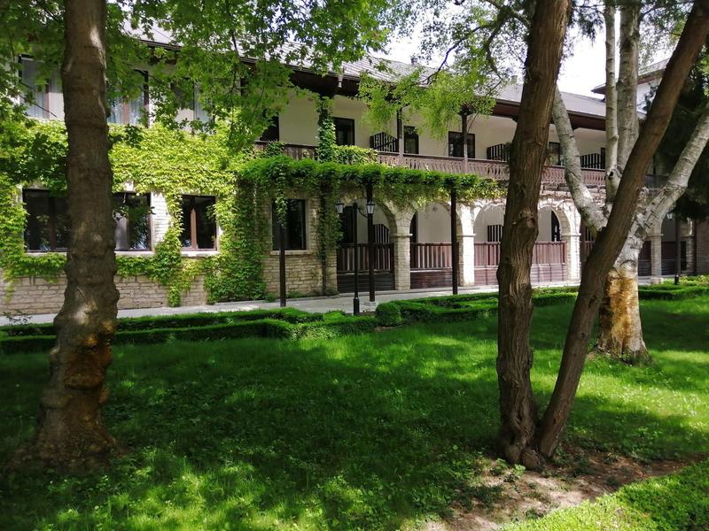 Begrüntes Hotelgebäude mit Bäumen und Wiese im Vordergrund