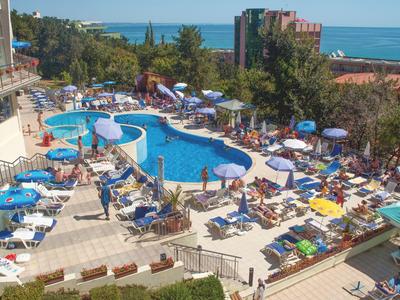 Elegancka część wypoczynkowa hotelu z okrągłymi miejscami do siedzenia, kwiatową dekoracją i nowoczesnym oświetleniem sufitowym.