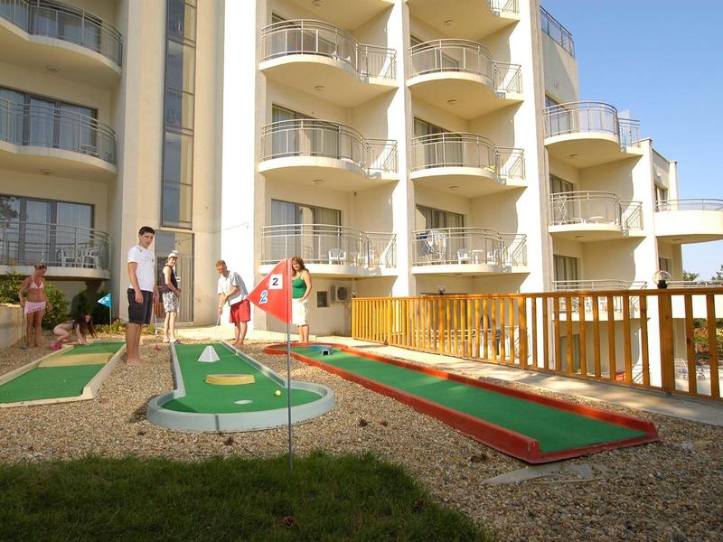 Moderne hotel lobby met lift in het midden, zitgedeeltes en grote ramen op de achtergrond.