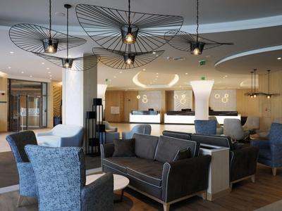 Hall d'hôtel moderne avec espaces de sièges et luminaires suspendus remarquables.