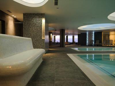 Modern binnenzwembad met verlichting en bank in een hotel