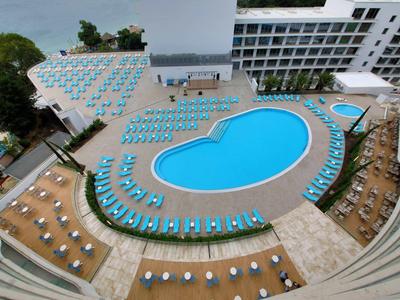 Groot hotelzwembad met ligstoelen en parasols