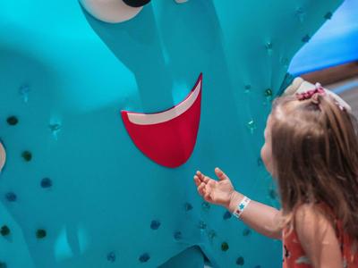 Malá dívka si hraje s velkou modrou usmívající se dekorativní hvězdicí.