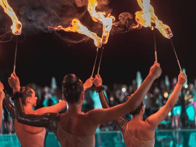 Plusieurs personnes agitent des torches enflammées lors d'un événement nocturne en plein air.