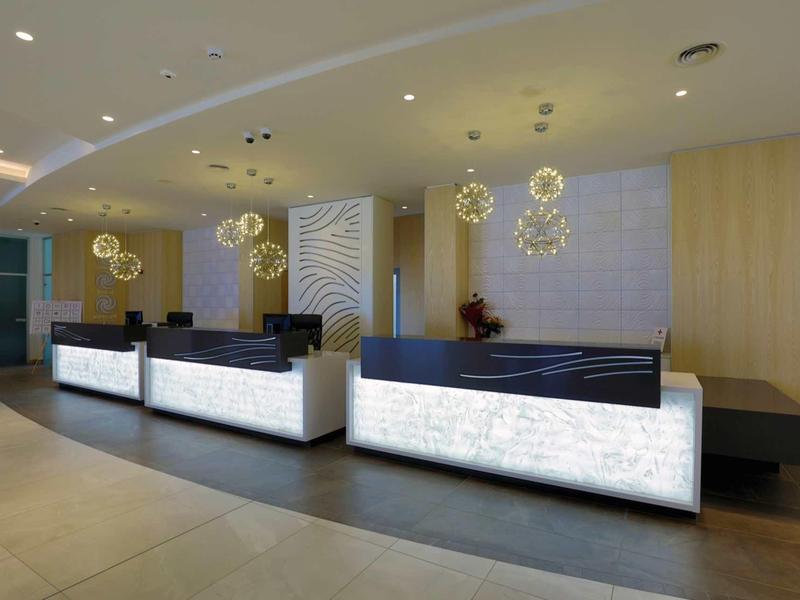 Moderne hotellobby met verlichte receptiebalie en stijlvolle kroonluchters.