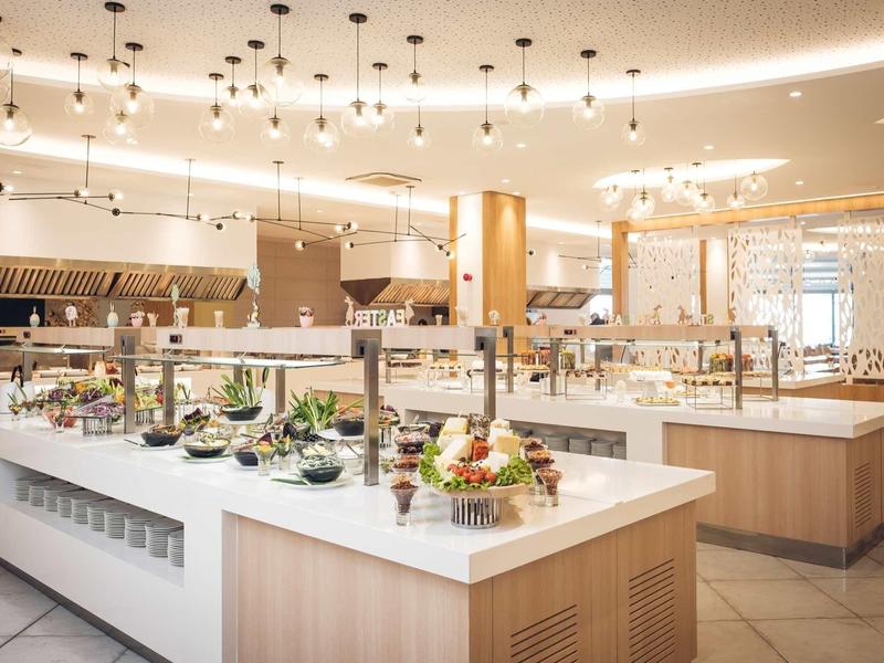 Helder, modern buffet met diverse gerechten en elegante decoraties in een restaurant.