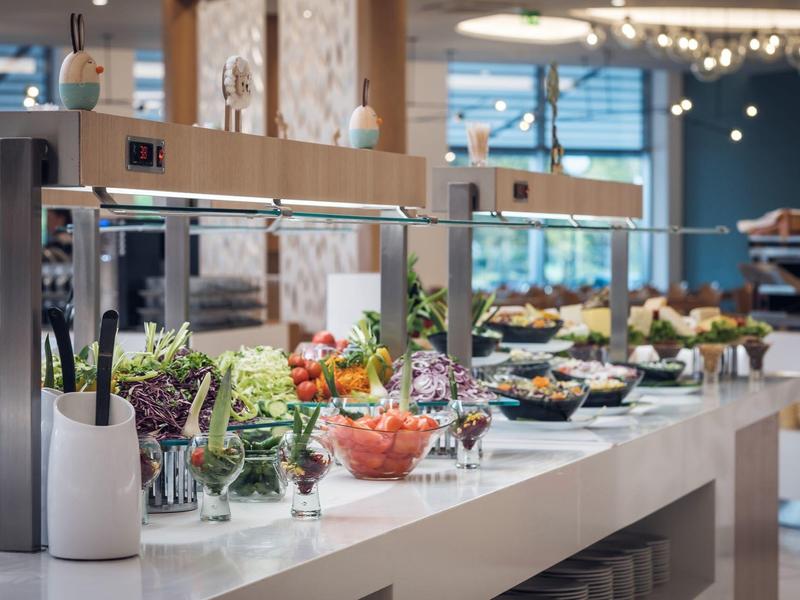 Bufet s čerstvými saláty a různými přílohami v moderní restauraci.