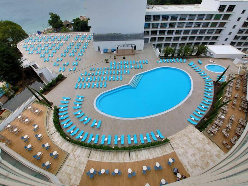 Groot hotelzwembad met ligstoelen en parasols