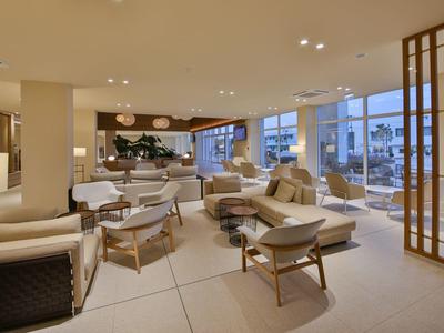 Elegante area lounge dell'hotel con poltrone comode e ampie viste dalle finestre.