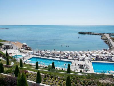 Lounge dell'hotel moderna con bar, divani e grande lucernario con vista sulla città.