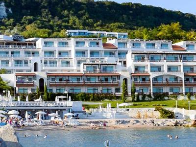 Modern eingerichtetes Wohnzimmer mit zwei grauen Sofas, weißem Couchtisch und kleinem Esstisch