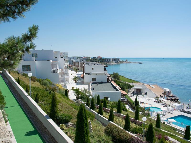 Ampia zona lounge moderna dell'hotel con piante e lampade rotonde sospese.