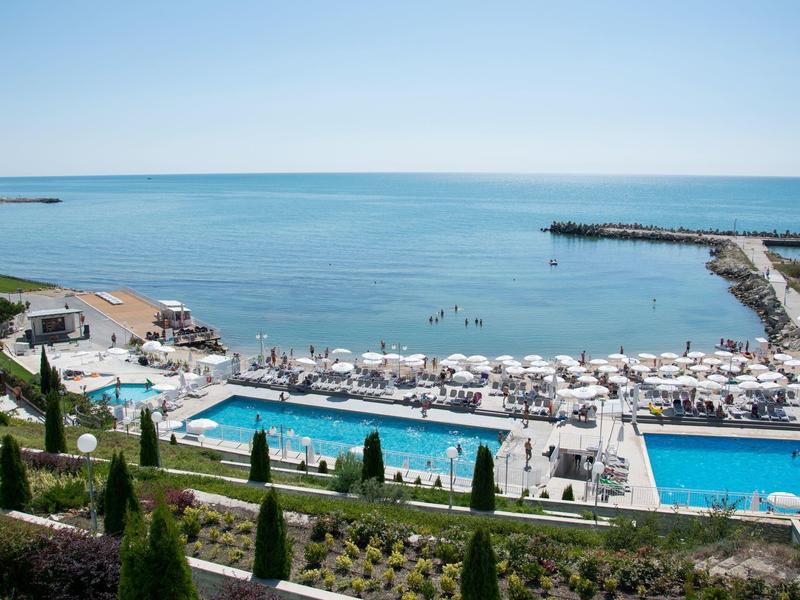 Lounge dell'hotel moderna con bar, divani e grande lucernario con vista sulla città.