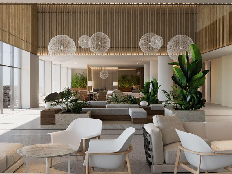 Lounge moderno dell'hotel con comode poltrone bianche, divani e piante verdi.