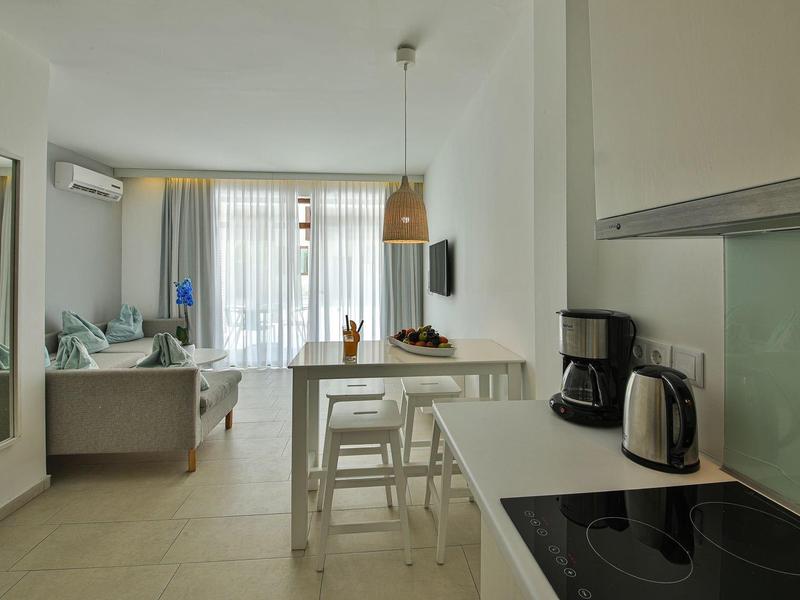 Appartamento luminoso e moderno con angolo cottura, zona pranzo e soggiorno con finestre sul balcone.