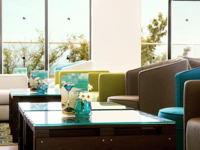 Espace salon d'hôtel lumineux et moderne avec canapés, fauteuils et grandes fenêtres