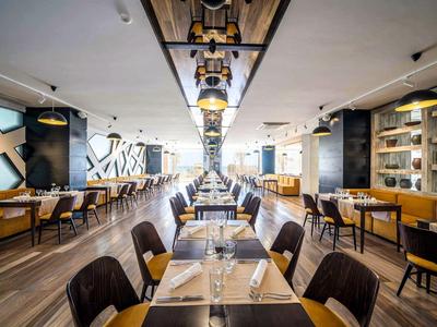 Restaurant moderne et lumineux avec tables élégamment dressées et intérieur chic.
